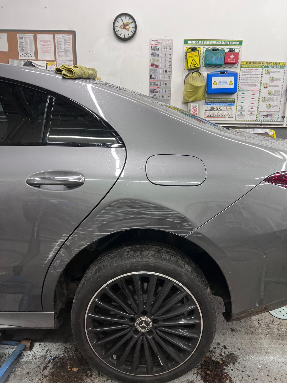 Wet Mercedes panel showing scratch damage on arrival